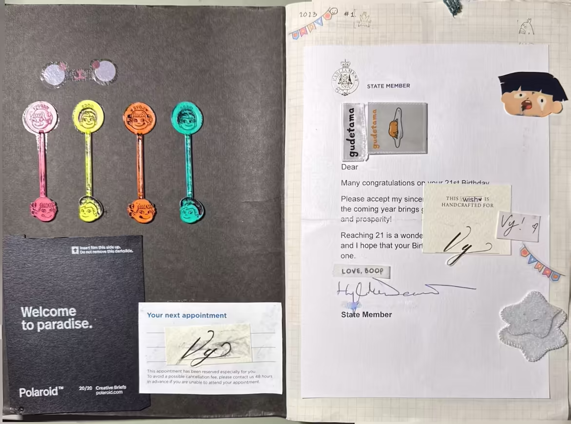 Spread of the front page. The left slide is the black cover with 4 candy sticks (left to right: pink, yellow, orange and blue) glued down. Below the candy sticks is a blank Polaroid cover, 'Welcome to Paradise' written, and to the right is an appointment card with 'Vy' in cursive written on it. The left side has the year the junk journal first started, ‘2023’ and a happy 21st birthday letter from a senator. The letter is decorated with stickers and more cursive lettering ‘Vy’, 2 small banner stickers and a hand-sewn felted white star.